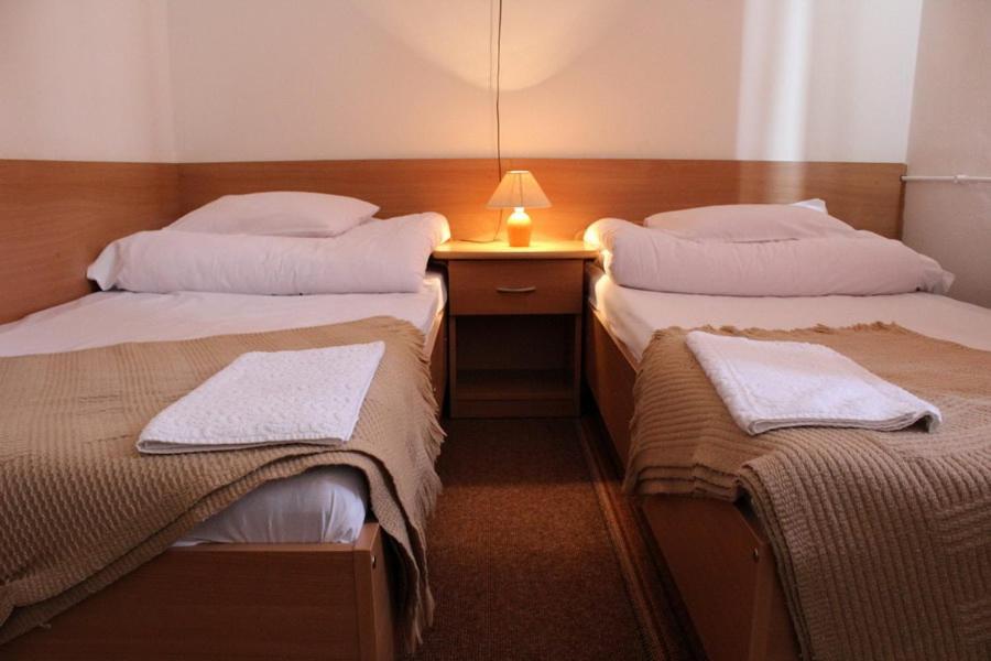 Habitación con 2 camas y escritorio con lámpara. en Hotel Europejski, en Przemyśl