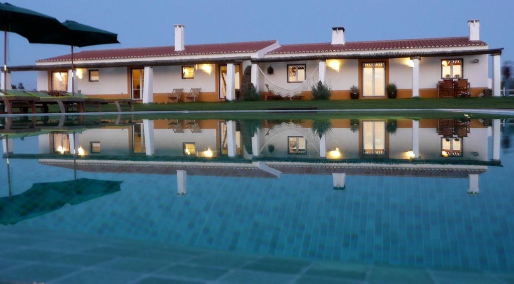 a house with a swimming pool in front of it at SeteQuintas in Zambujeira do Mar