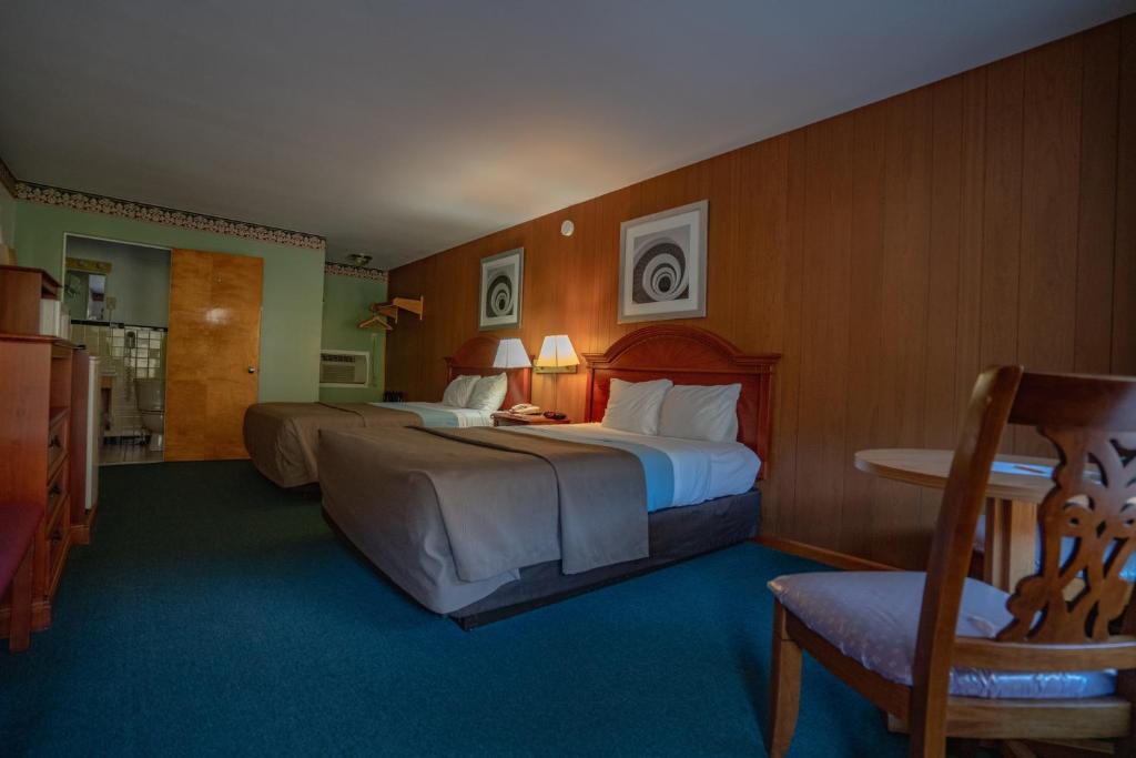 um quarto de hotel com duas camas e uma cadeira em Mahoning Inn em Lehighton