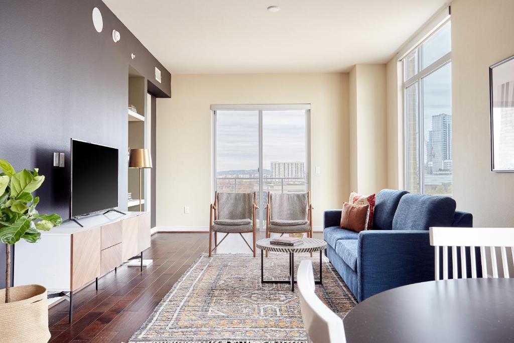 a living room with a blue couch and a tv at Sonder at The Catherine in Austin