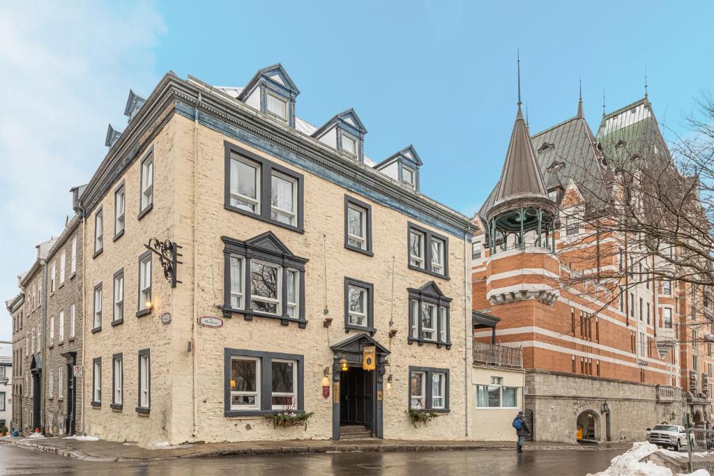 um grande edifício de tijolos numa rua da cidade em Hotel Jardin du Gouverneur em Cidade de Quebec