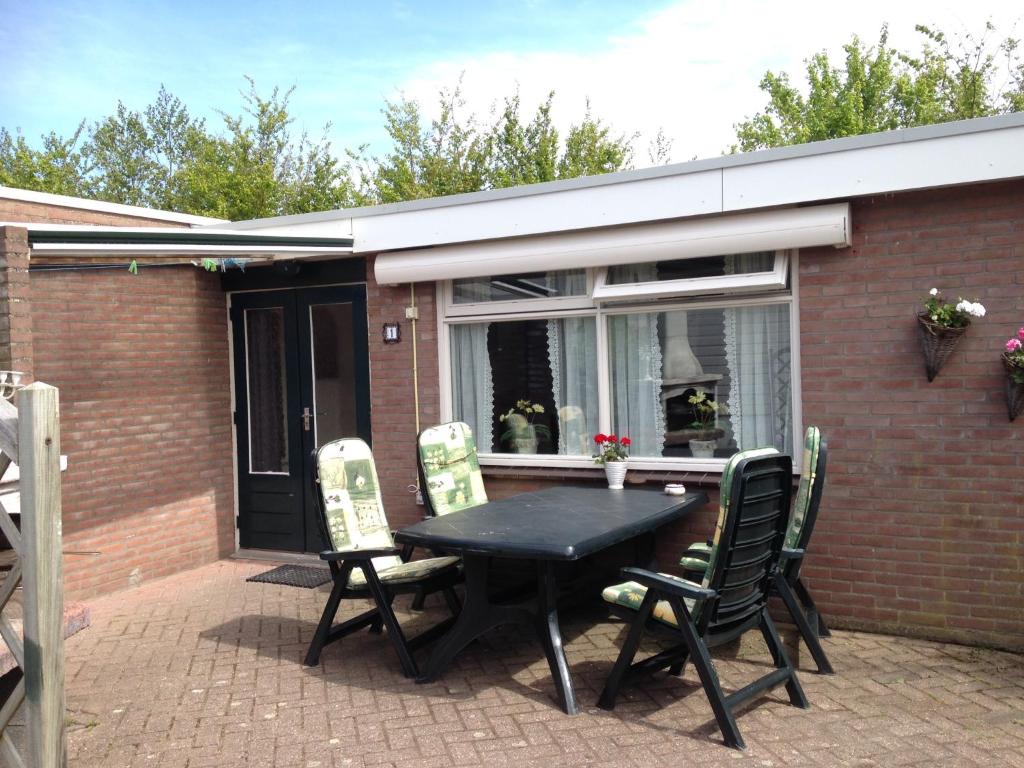 una mesa negra y sillas en un patio en De Vlinder Renesse, en Renesse