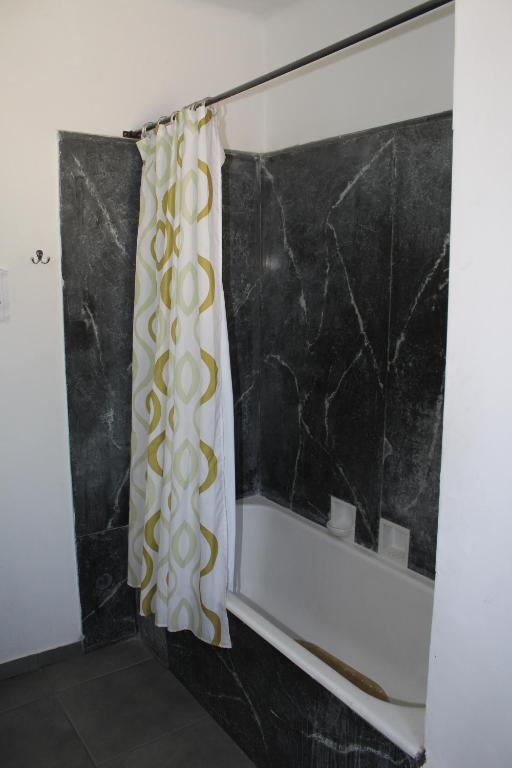 a shower curtain in a bathroom with black and white at Aji Hostel in Santiago