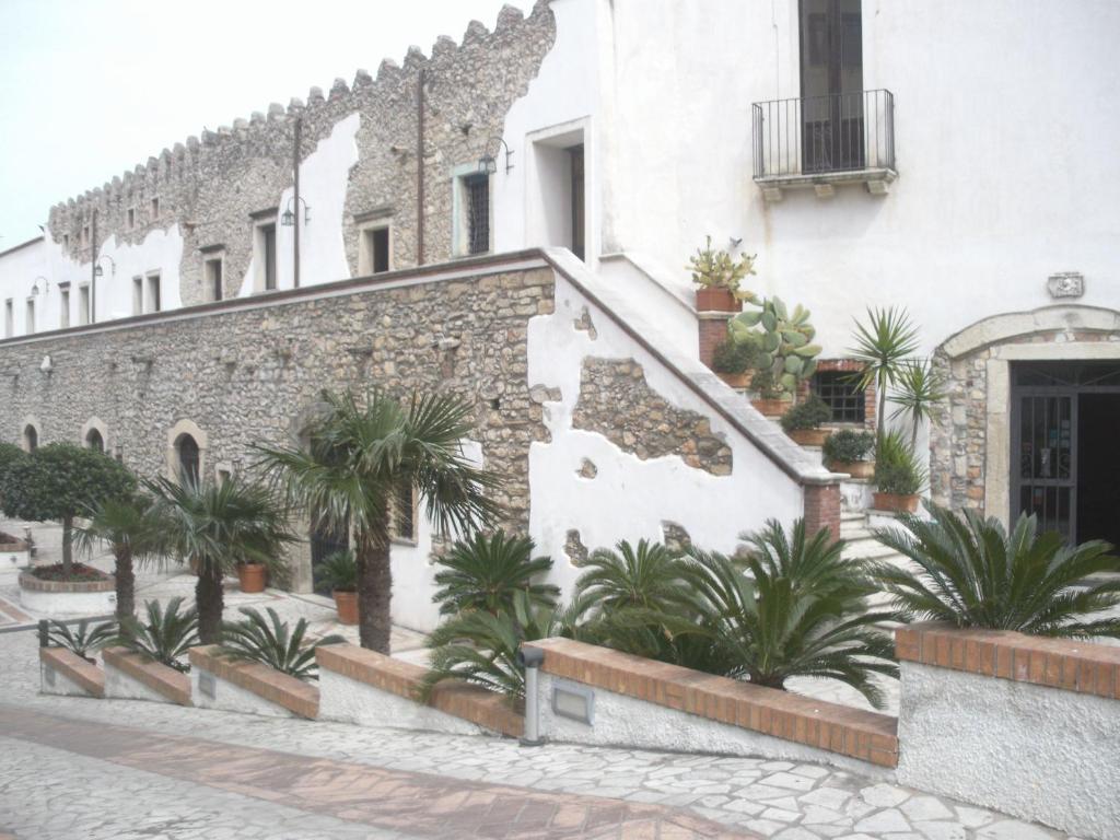 a building with palm trees in front of it at Hotel Residence La Fortezza in San Lucido