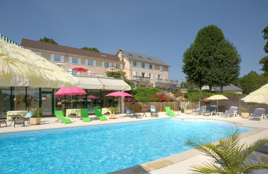 a swimming pool with chairs and umbrellas at Bel Horizon in Le Chambon-sur-Lignon