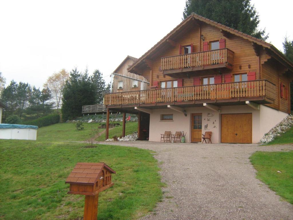 ein großes Holzhaus mit Balkon darüber in der Unterkunft Chalet Gérardmer situé a LE THOLY in Le Tholy