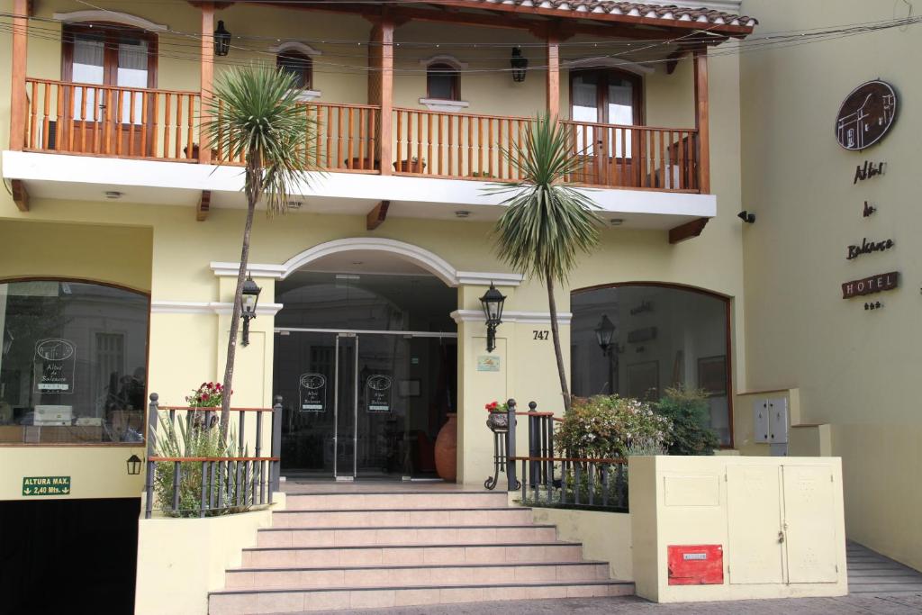 an entrance to a building with stairs and palm trees at Altos De Balcarce Hotel in Salta