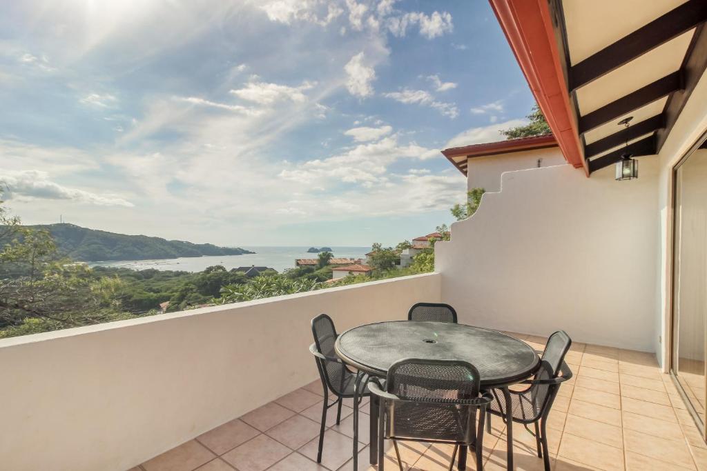 balcone con tavolo, sedie e vista sull'oceano di Villa Sol 66-3 a Playa Hermosa