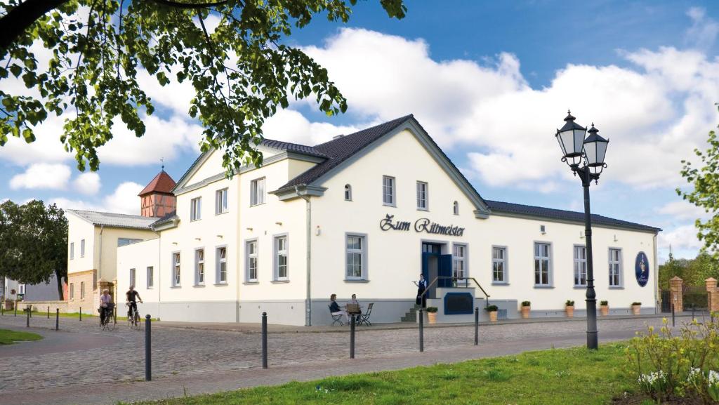 - un grand bâtiment blanc avec un panneau dans l'établissement Zum Rittmeister, à Werder