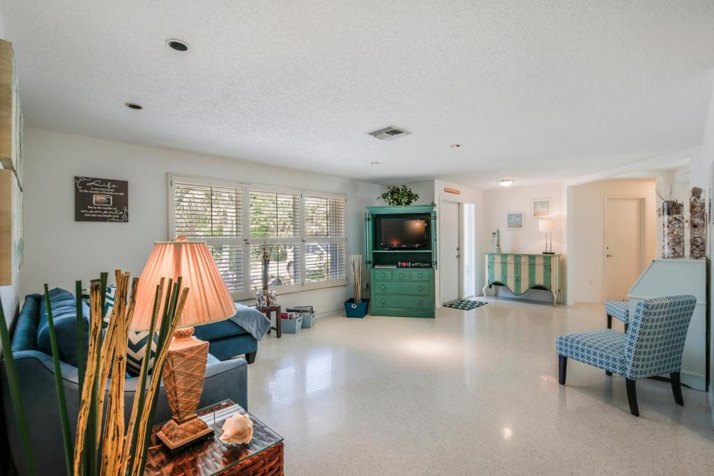 a living room with blue furniture and a tv at Villa Island Pearl - Roelens Vacations in Sanibel