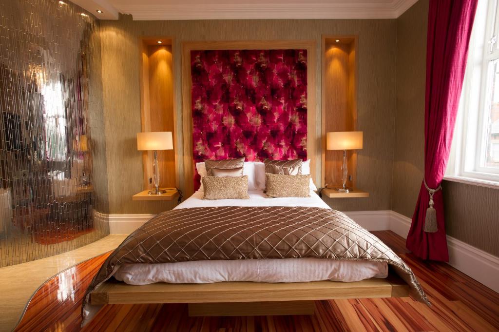 a bedroom with a large bed with a red headboard at Breck Apartments in Poulton le Fylde