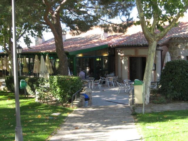 a house with a patio with tables and chairs at Hotel Restaurante Sonsoles in Ávila