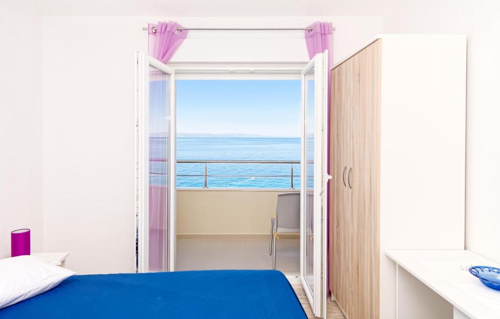 een slaapkamer met een bed en uitzicht op de oceaan bij Apartman More&Maslina in Drasnice