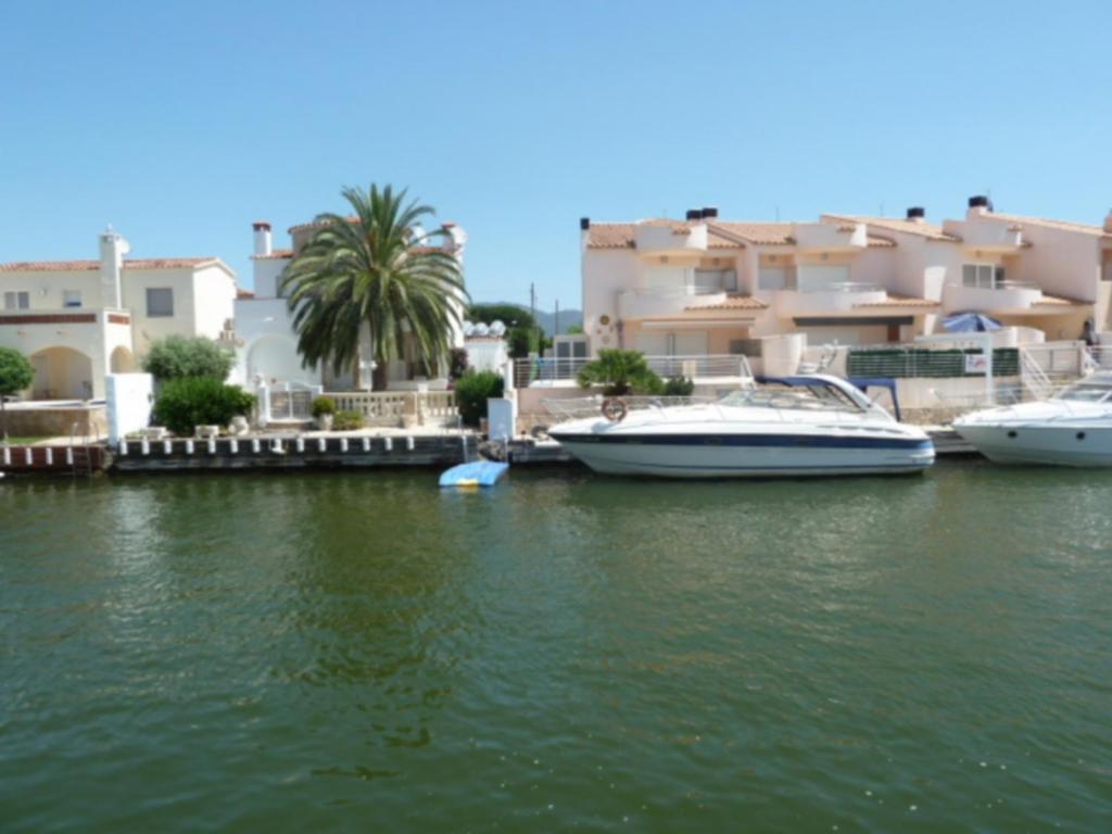 a group of boats docked in a river with buildings at casa con amarre privado ref 214 in Empuriabrava