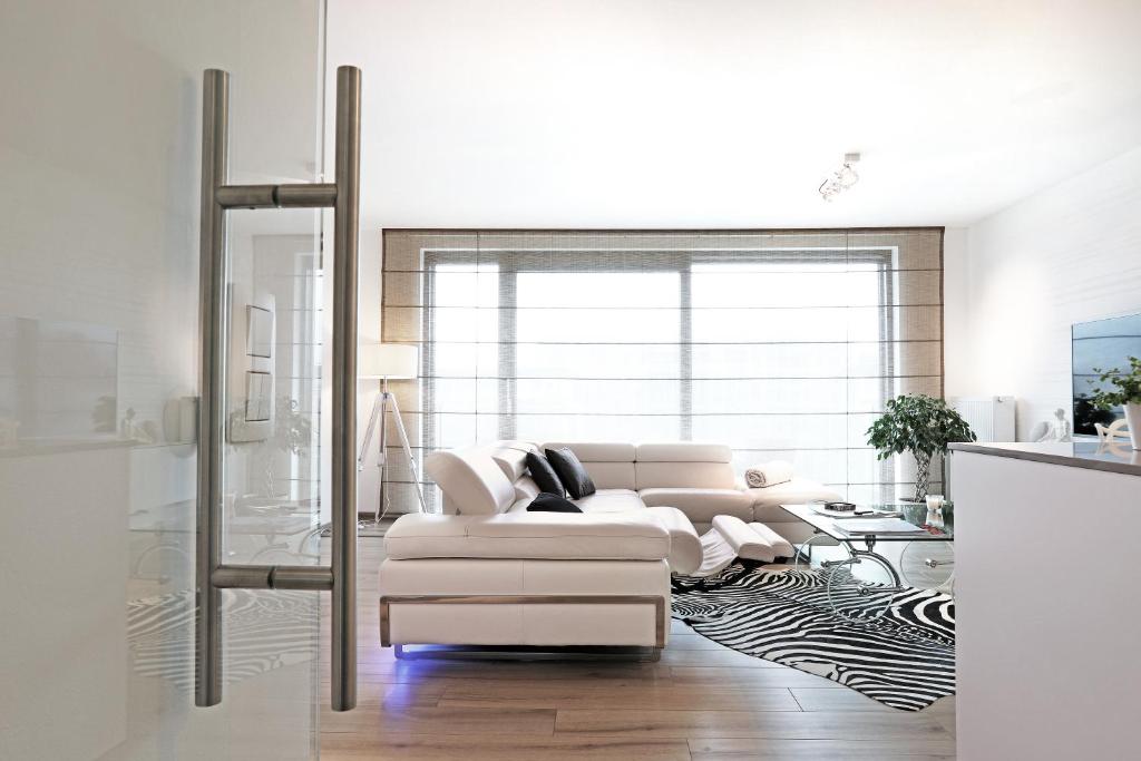 uma sala de estar com um sofá branco e uma mesa em Luxury Suite Koksijde 301 Adult only em Koksijde