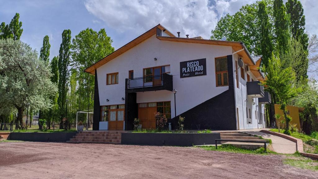 un edificio con un cartel en el costado en Hotel Risco Plateado Room & Suite en Malargüe