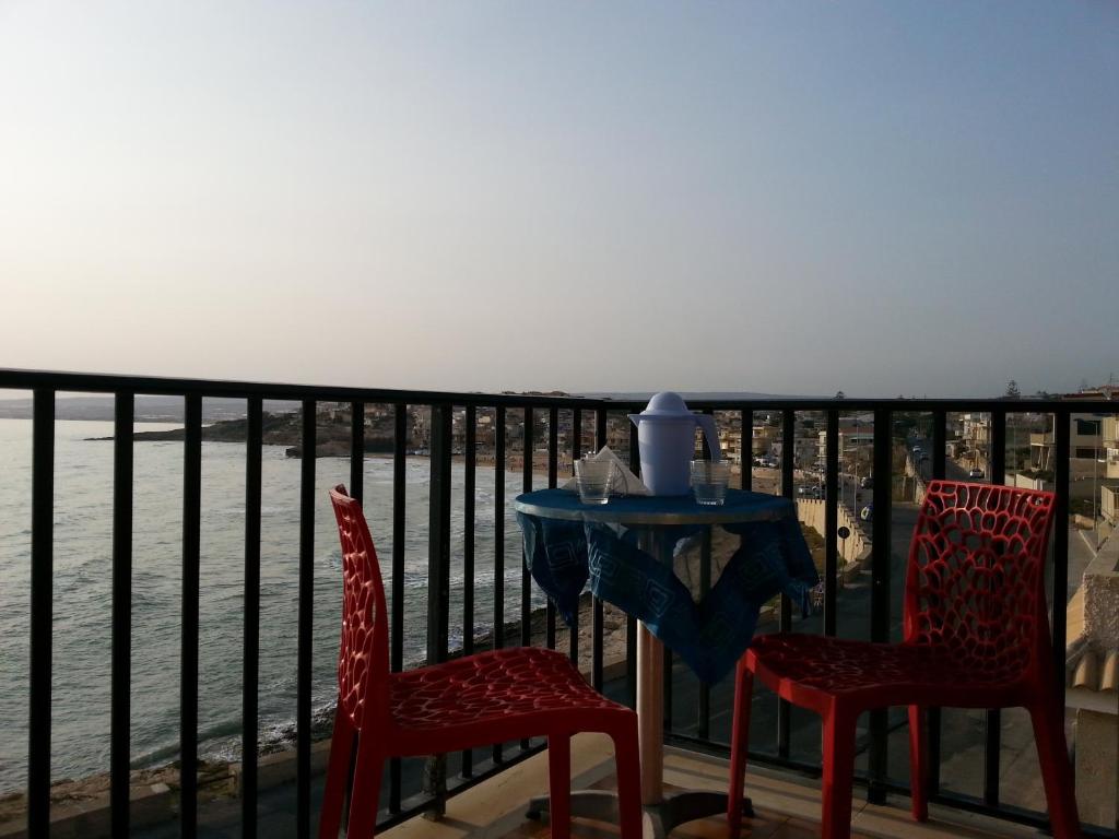 una mesa y 2 sillas en un balcón con vistas al agua en Mavì, en Cava dʼAliga