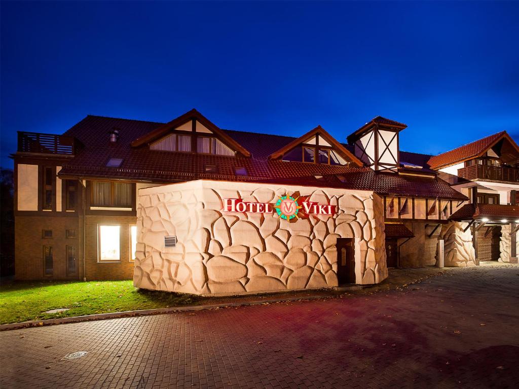 a hotel with a stone wall in front of a building at Hotel Viki in Szczecinek