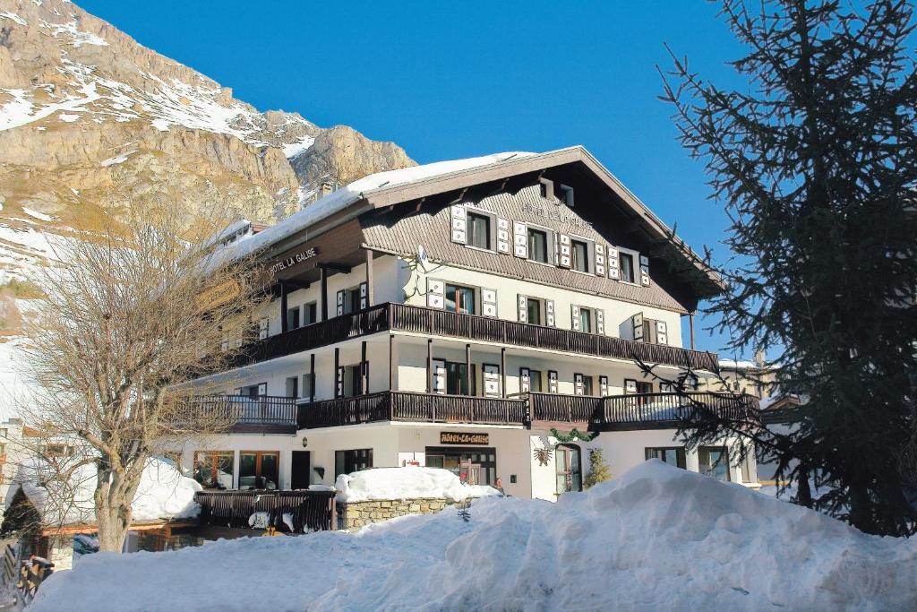 een groot gebouw in de sneeuw voor een berg bij La Galise in Val dʼIsère