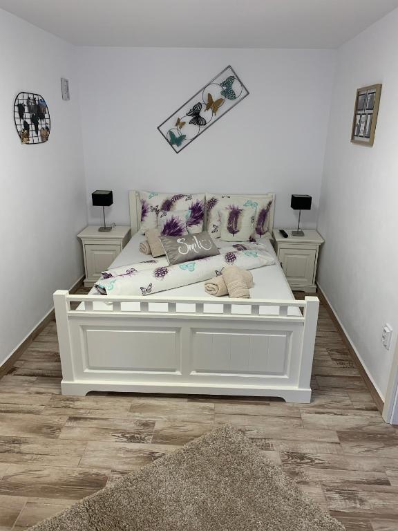 a white bed in a room with two night stands at Smiley Rezident in Sibiu