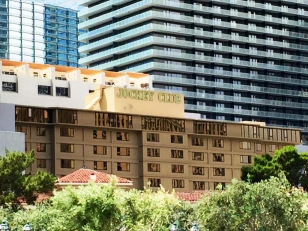 un hôtel avec un panneau au-dessus d'un bâtiment dans l'établissement GetAways at the Jockey Club, à Las Vegas