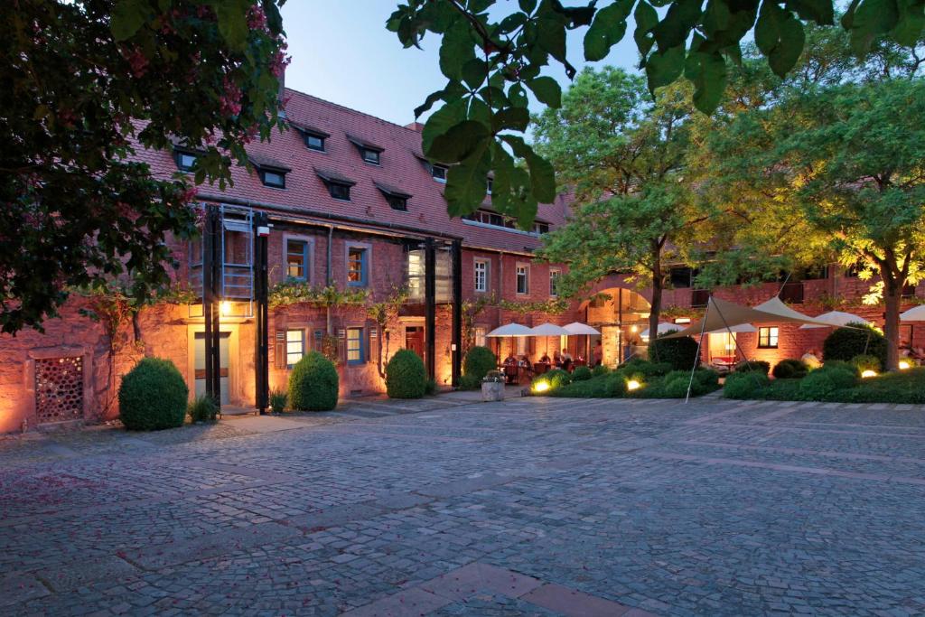 une cour en face d'un grand bâtiment dans l'établissement Mühle am Schlossberg, à Wartenberg-Rohrbach