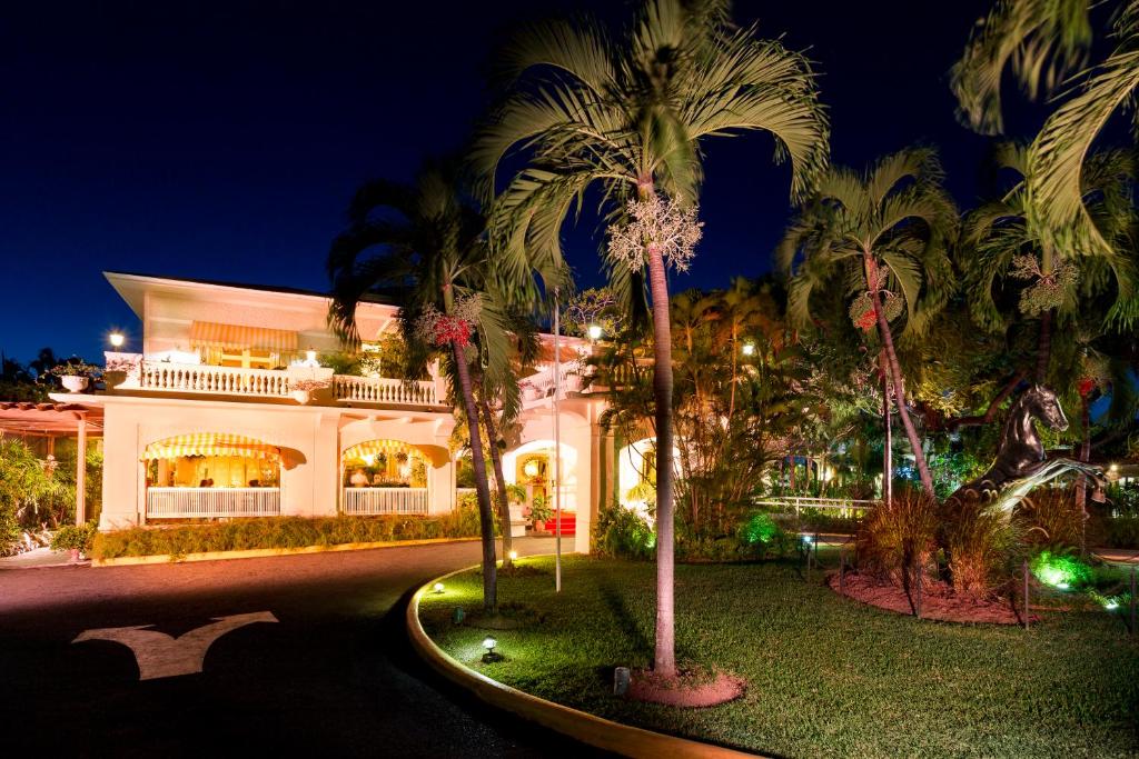 a large white building with palm trees in front of it at Terra Nova All Suite Hotel in Kingston