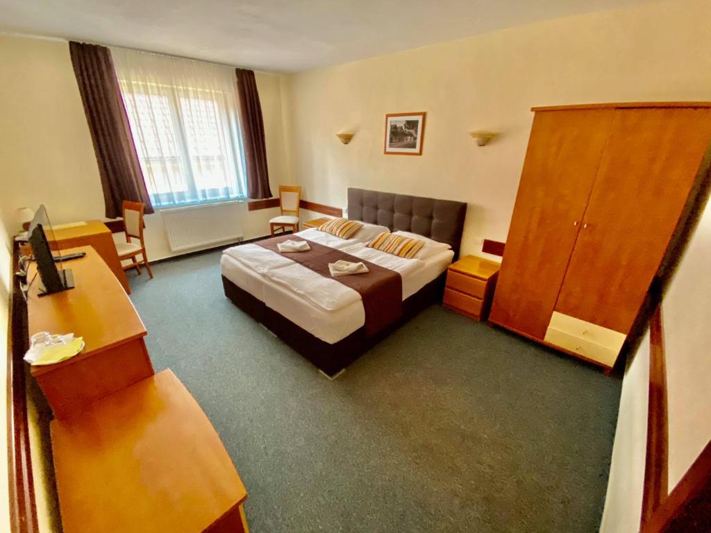 a hotel room with a bed and a desk at Garni Hotel Tatramonti in Poprad