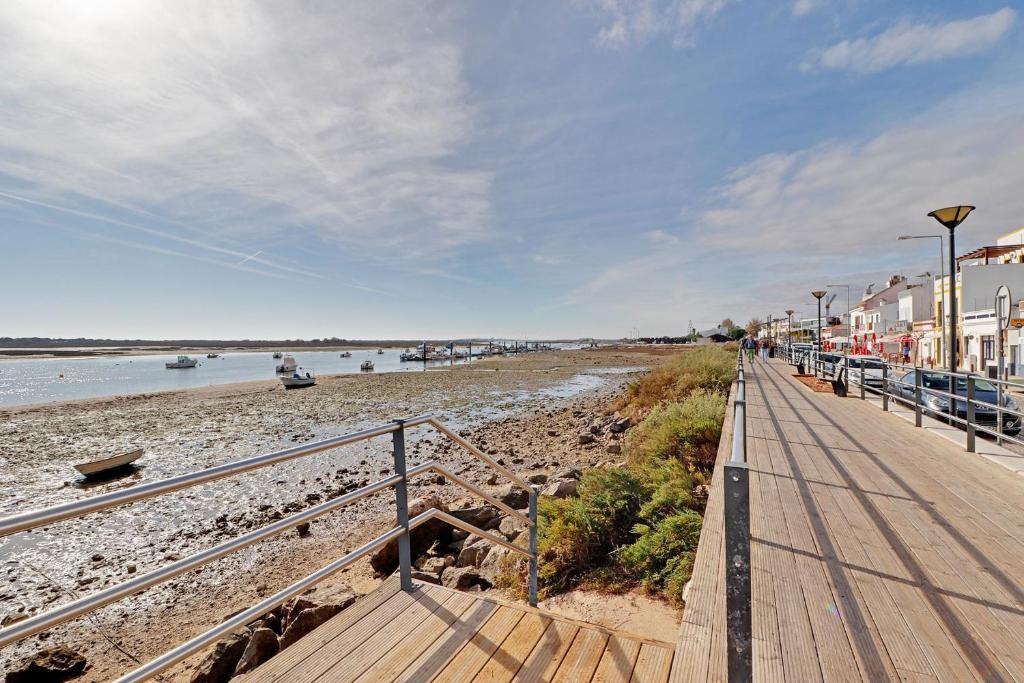 a boardwalk leading down to a beach with houses at Tavira Formosa Bay by Homing in Cabanas de Tavira