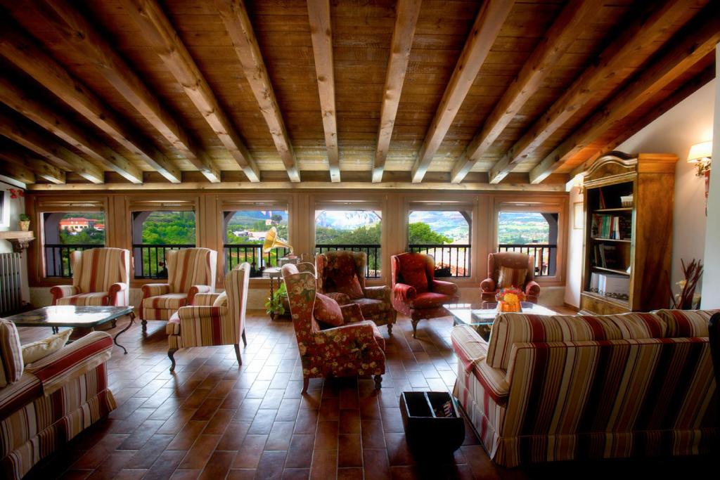 una gran sala de estar con sofás, mesas y ventanas. en Casa Rural Torredano, en Nalda