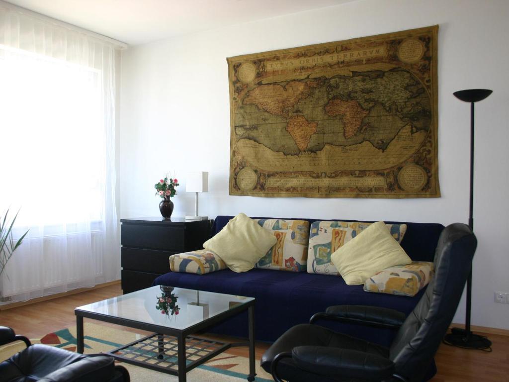 ブダペストにあるArriva Apartment, optional indoor parkingのリビングルーム(青いソファ付)、壁の地図