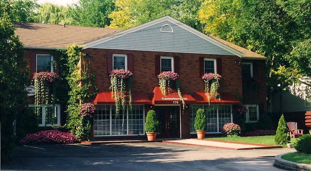 a red brick house with flowering plants on it at Canterbury Inn in Niagara-on-the-Lake