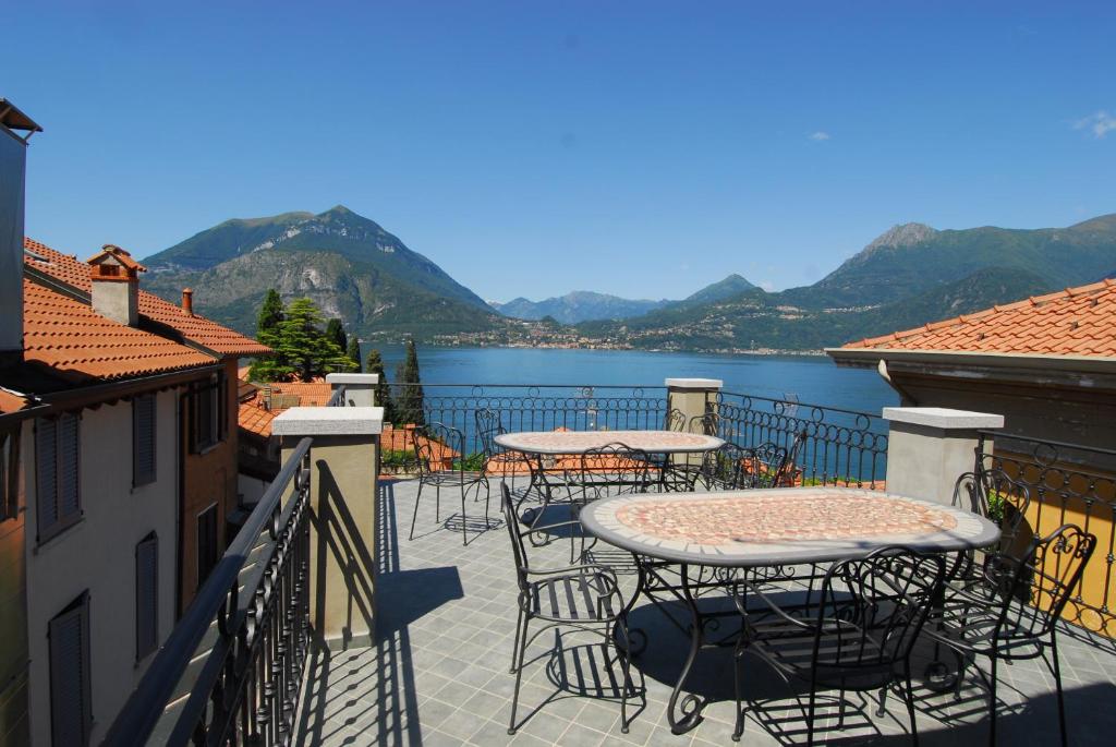 a balcony with tables and chairs and a view of a lake at Fiò & Giò in Varenna