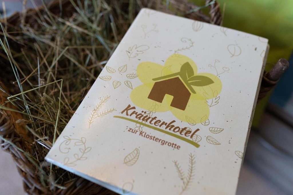 a card in a basket with a house on it at Kräuterhotel Garni Zur Klostergrotte in Nohra