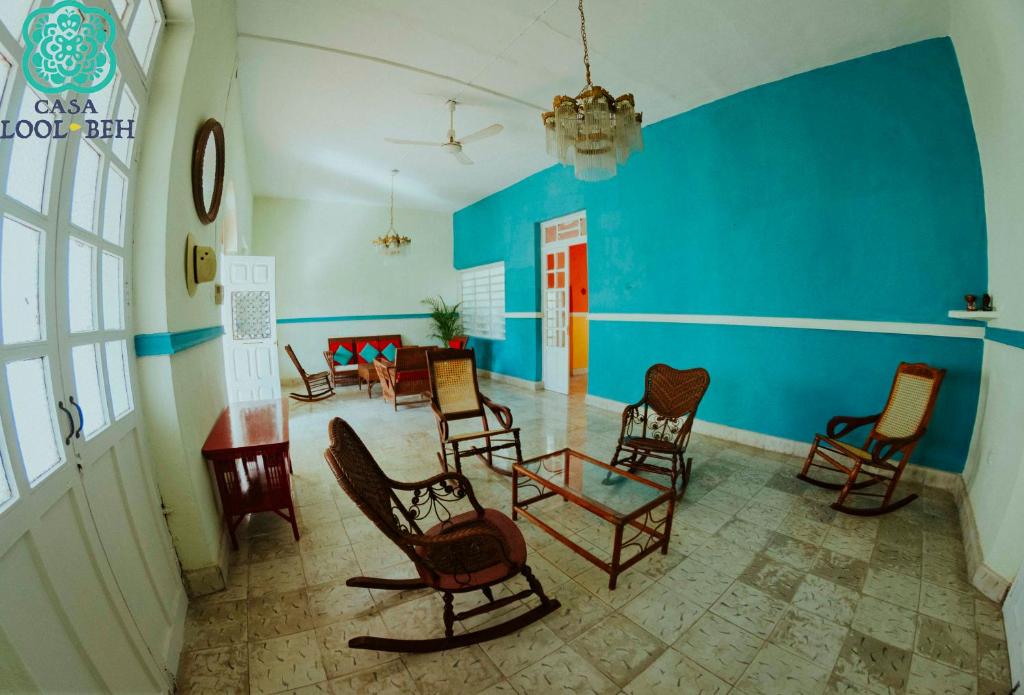 une chambre avec des chaises et un mur bleu dans l'établissement Casa Lool Beh, à Mérida