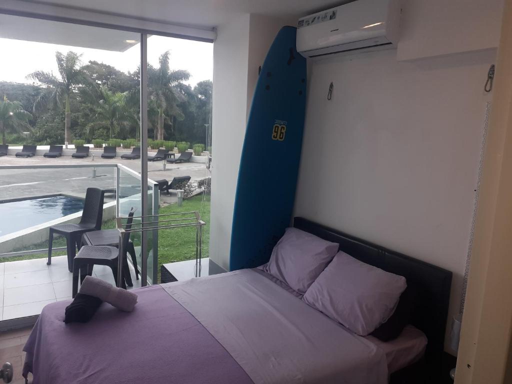 1 dormitorio con 1 cama y balcón con vistas. en Apartamento en BalaBeach María Chiquita in front of the beach 2hab en Colón