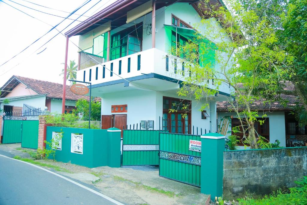 una casa con una recinzione verde davanti di Ananda Villa Bentota a Bentota