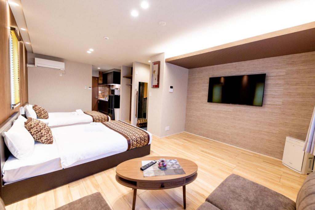 GRAND BASE Hiroshima Hikarimachi في هيروشيما: غرفة فندقية بسرير وتلفزيون بشاشة مسطحة