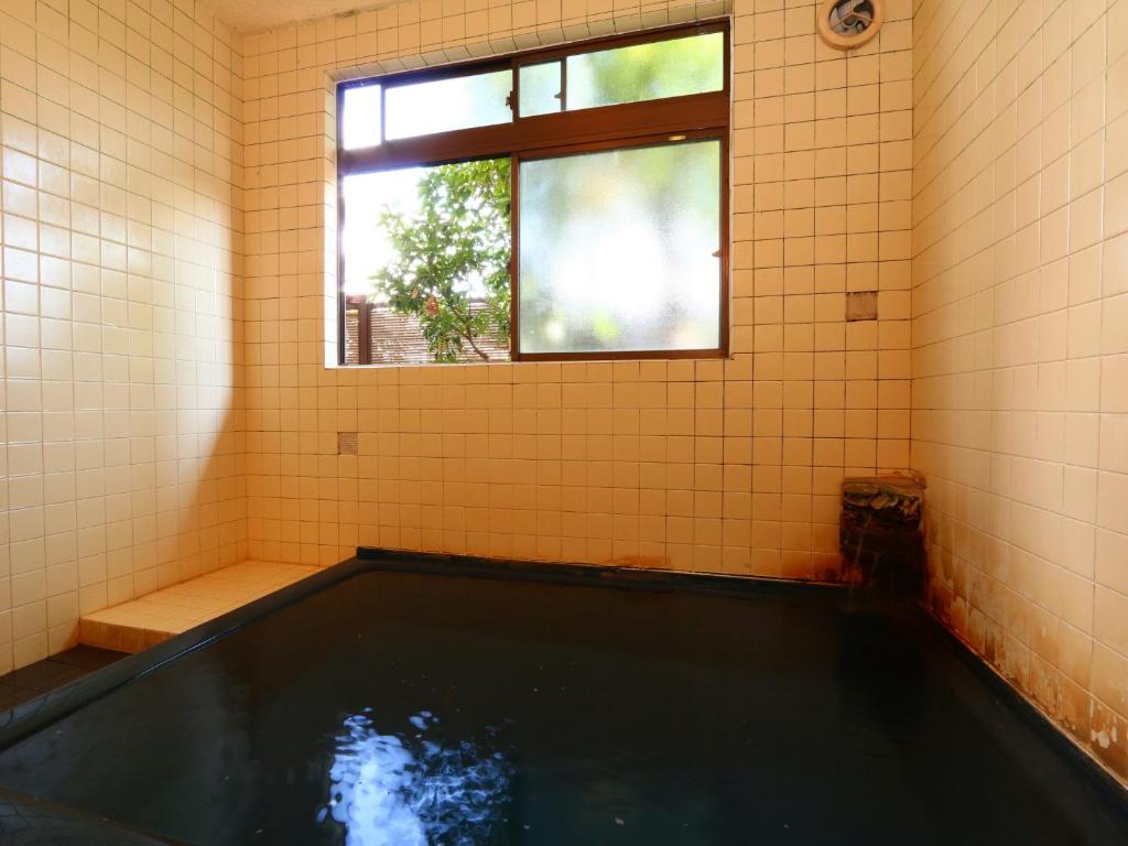 a swimming pool in a room with a window at Hakuraiso in Matsumoto