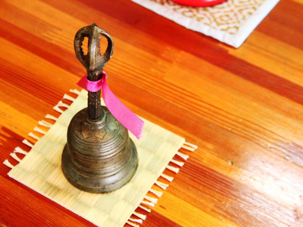 a small vase with a pink ribbon on a table at Hakuraiso in Matsumoto