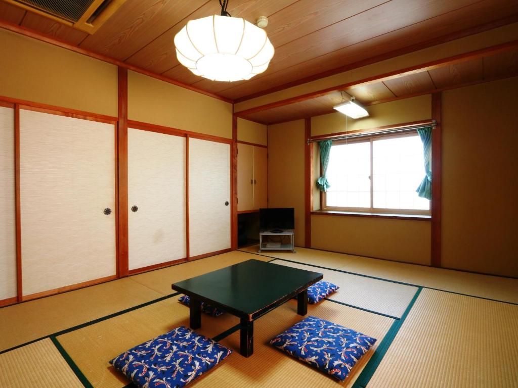a room with a table and two pillows at Hakuraiso in Matsumoto