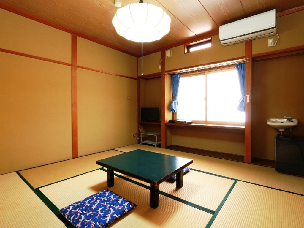 a living room with a table and a window at Hakuraiso in Matsumoto