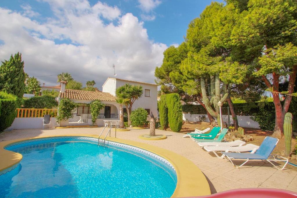 una piscina con sillas y una casa en Condelmar - modern villa close to the beach in Calpe, en Calpe
