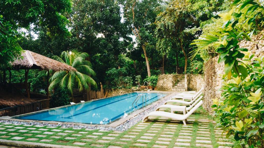 una piscina con sedie a sdraio e un resort di The Strand Boutique Resort a Boracay