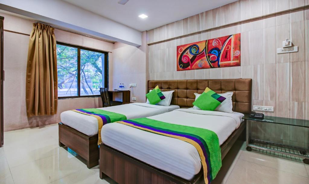 a bedroom with two beds and a window at Treebo Trend Lake Bloom Powai in Mumbai
