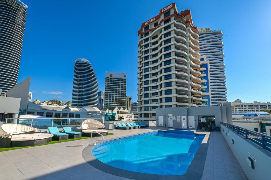 a swimming pool on the roof of a building with tall buildings at Victoria Square Apartments in Gold Coast