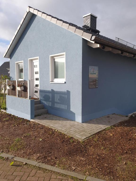 una pequeña casa azul con porche en Feriendomizil-Usetom, en Ückeritz