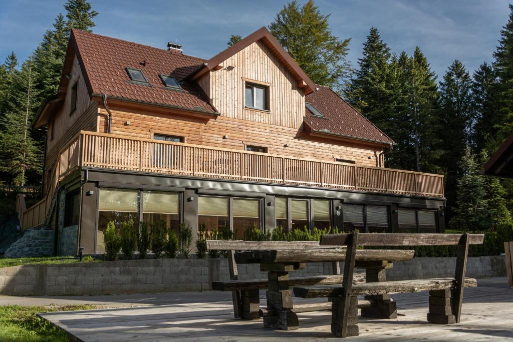 a wooden house with a bench in front of it at Apartments Storzek in Hočko Pohorje