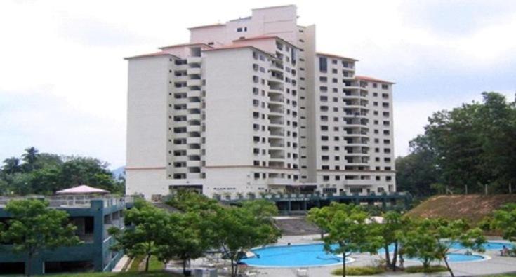 um grande edifício branco com uma piscina em frente em Lumut Valley Condominium em Lumut