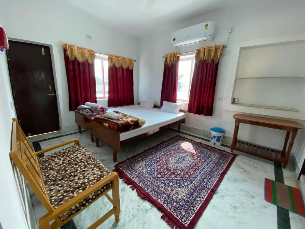 um quarto com uma cama, um sofá e uma mesa em Rahul Guest House em Bodh Gaya